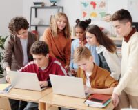 Leerlingen werken samen aan laptops in een klaslokaal