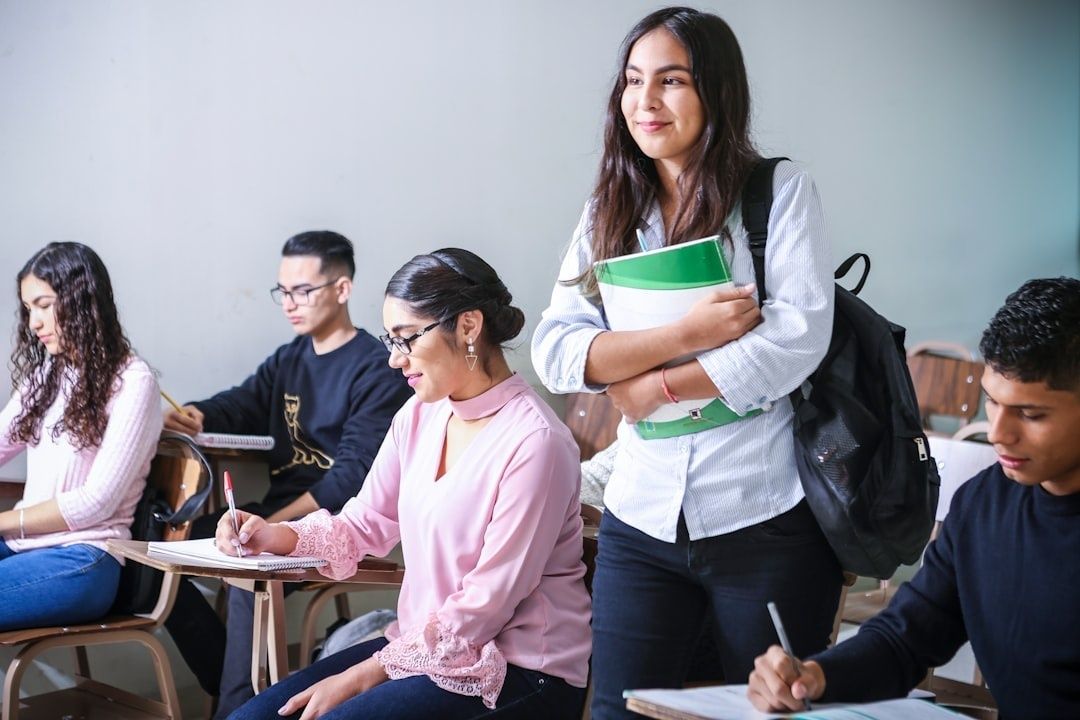 Leerlingen werken in een klas terwijl een student met boeken binnenkomt