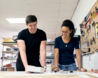 Twee jonge mensen werken samen aan een werkbank in een gereedschapsatelier