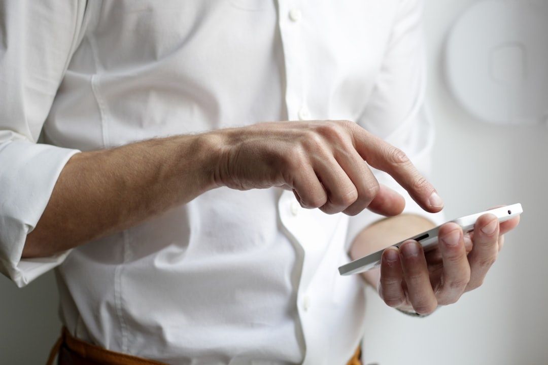 Persoon in wit overhemd gebruikt een smartphone voor korte leermomenten